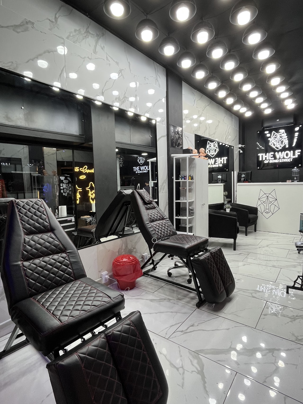 Interior del estudio The Wolf of Bond Street con sillones de tatuaje y cartel del lobo
